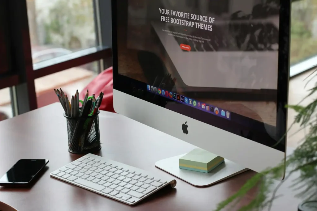 Silver Apple iMac and Keyboard on brown desk